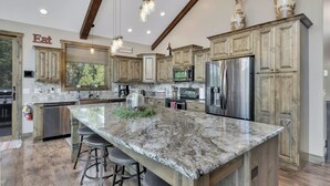 A spacious kitchen with granite countertops, stainless steel appliances, and wooden cabinets. - Aspen Valley, Deadwood SD (Sturgis)