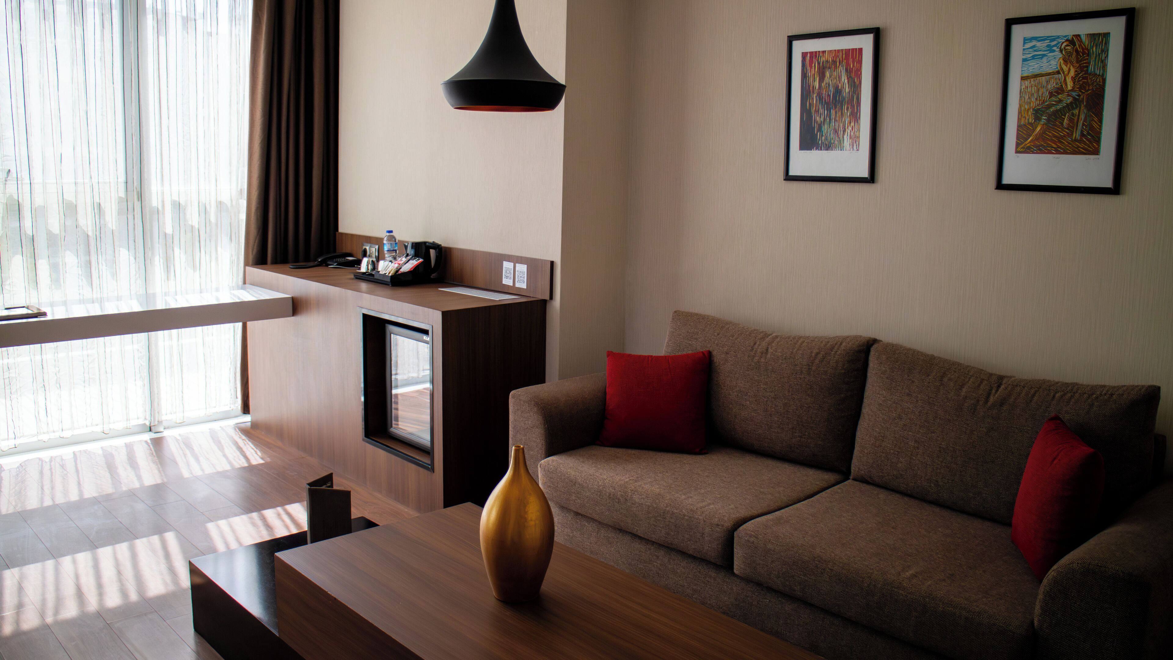 Een moderne woonkamer met een bank, een bijzettafeltje en een werkplek.