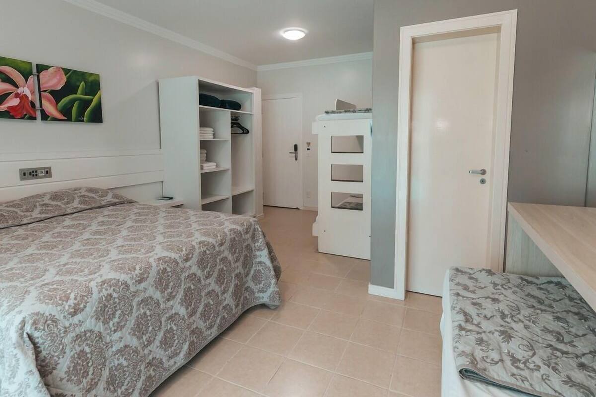 A bedroom with a bed, a wardrobe, and a door.