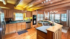 A spacious kitchen with wooden cabinets, a refrigerator, and a dishwasher. - Spacious Cabin for 14 on Fightingtown Creek – Private Trout Fishing Retreat (McCaysville)