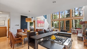 A modern kitchen with a central island, large windows, and a dining area with leather chairs. - Polecat Chalet 4 Bedroom Home by RedAwning (Telluride)