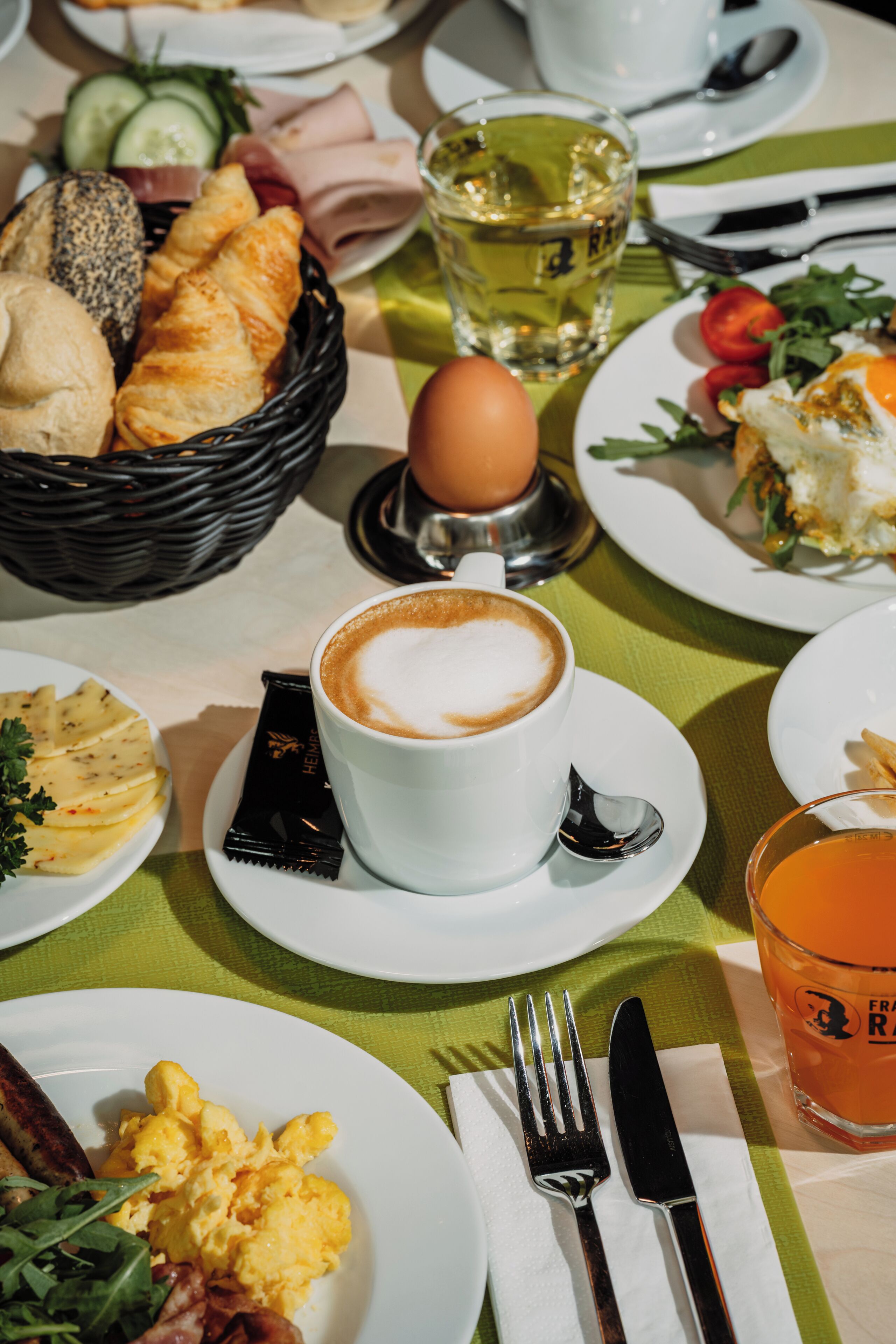 Un desayuno con cruasanes, huevos revueltos y una taza de café.