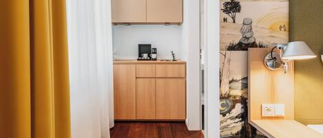 Una cocina moderna con armarios de madera, una cafetera y una lámpara de pared.