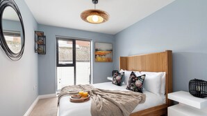 A bedroom with a bed, bedside table, and a window with blinds. - Beautiful 2 Bedroom Apartment With Parking in The Docks (Gloucester)