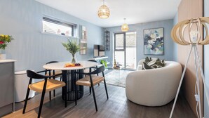 A modern living space with a dining area, a round table, and a comfortable seating arrangement. - Beautiful 2 Bedroom Apartment With Parking in The Docks (Gloucester)