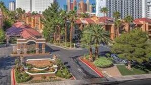 A hotel with a central courtyard, surrounded by palm trees and a parking area. - Las Vegas 1Bed/1Bath, Desert Rose! (Las Vegas)