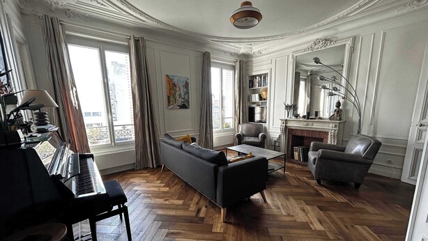 Un salon spacieux avec un piano, un canapé, une table basse et une cheminée.