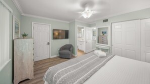 A bedroom with a bed, a dresser, a chair, and a television. - Romantic Island Getaway! Just Steps from the Beach (Bradenton Beach)