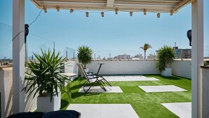 A rooftop patio with a pergola, outdoor furniture, artificial grass, and potted plants. - Casa Loresa Silver (Orihuela)
