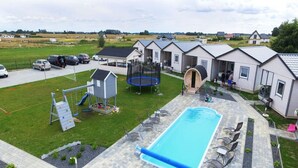 Un quartier résidentiel doté d’une piscine, d’un espace extérieur aménagé, d’un trampoline et d’une petite aire de jeux.
