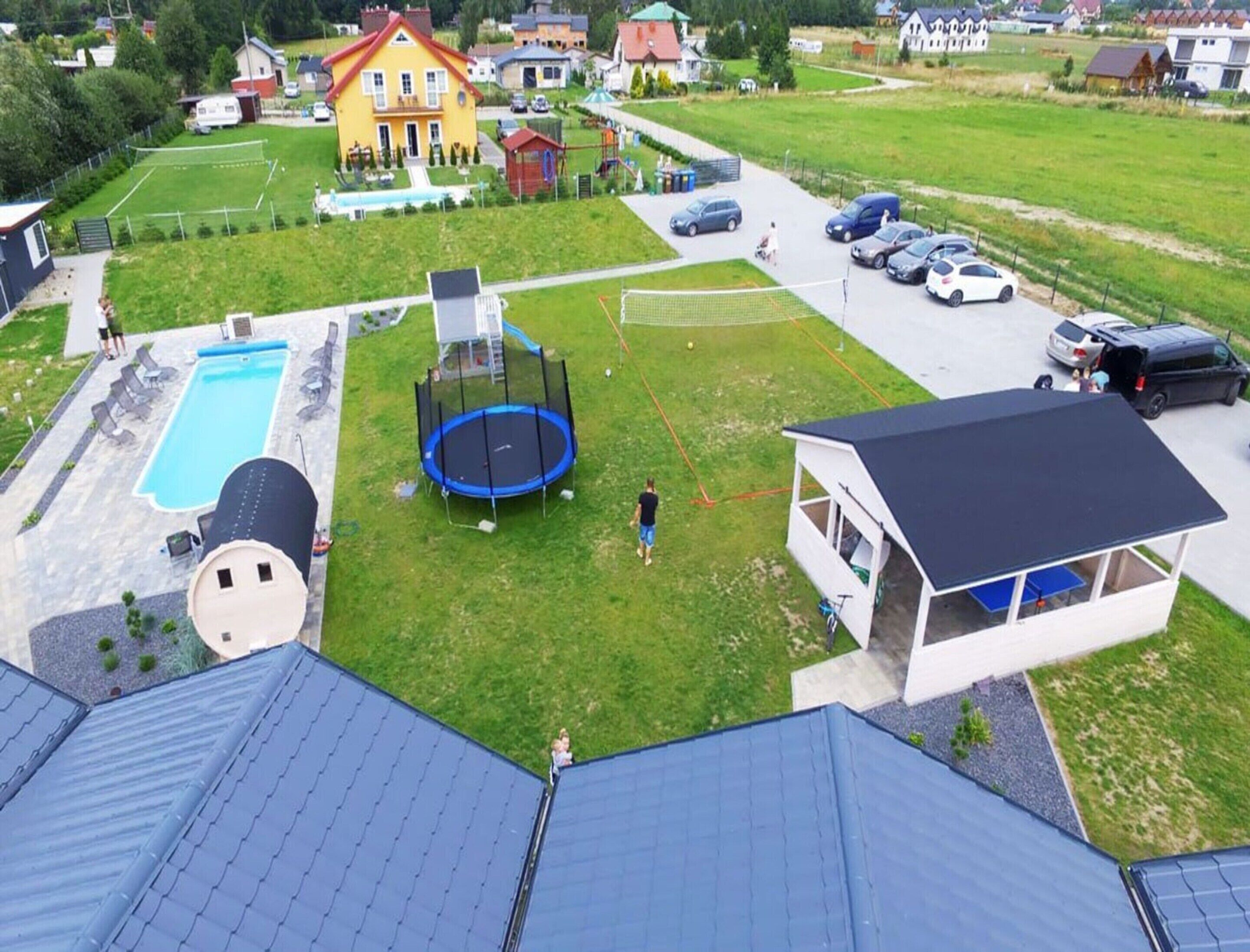A residential area with a swimming pool, trampoline, and a covered outdoor seating area.