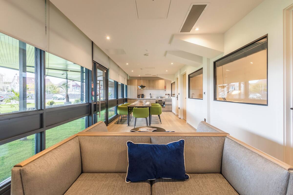 A modern interior with a seating area, a dining space, and a kitchen.