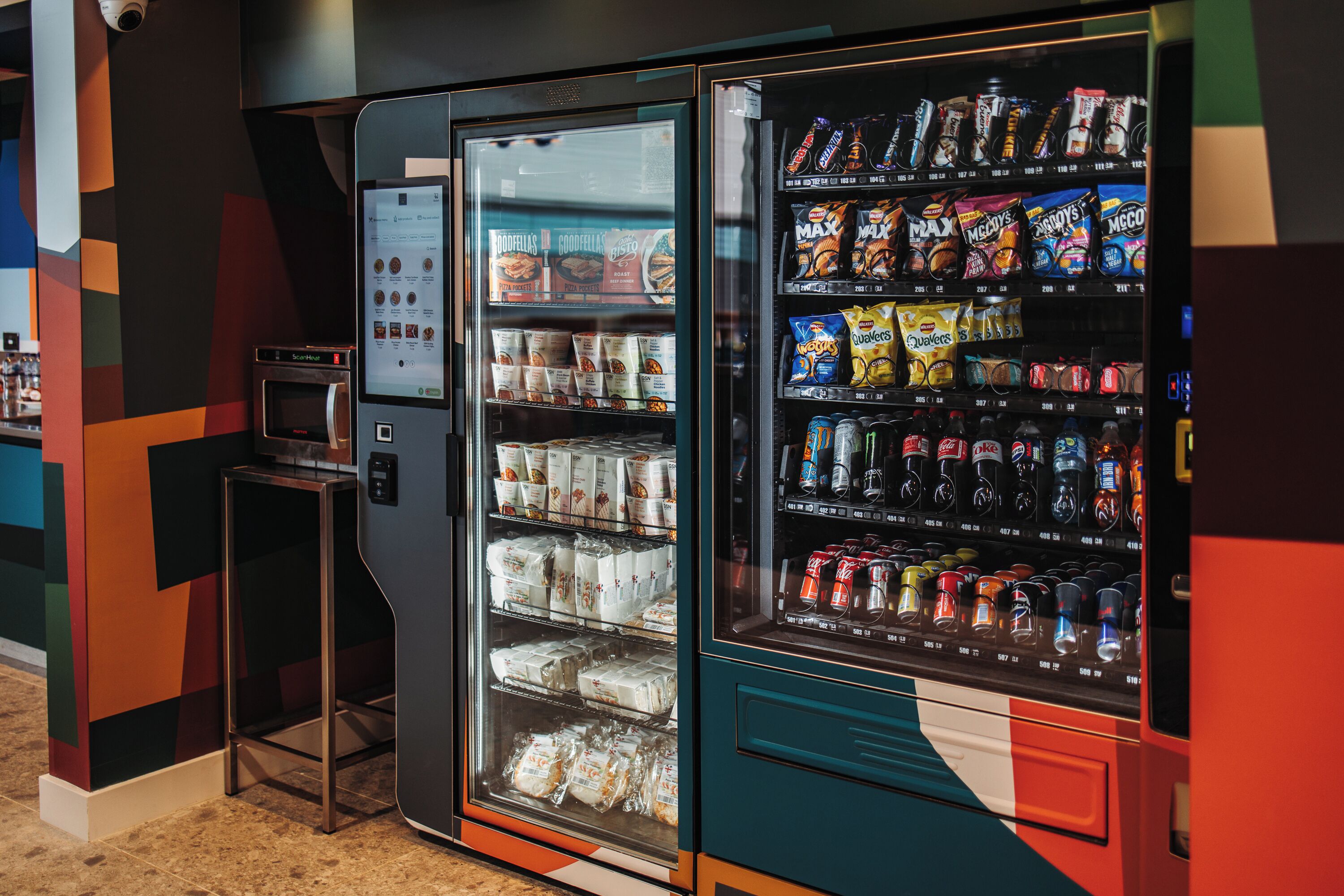 A vending machine with snacks and beverages, a microwave, and a digital display.