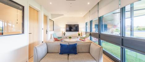 A modern living room with a sofa, a coffee table, and a TV.