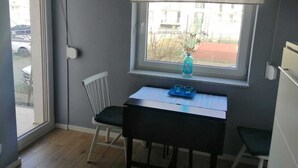 Une petite pièce avec une fenêtre, une table et une chaise.