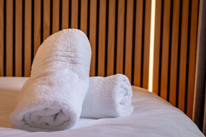 A neatly made bed with two rolled white towels placed on it. - Muttoes Apartments (No 21) (St Andrews)