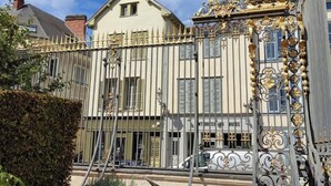 Ein historisches Gebäude mit aufwendigen schmiedeeisernen Gittertüren und einer klassischen Fassade.