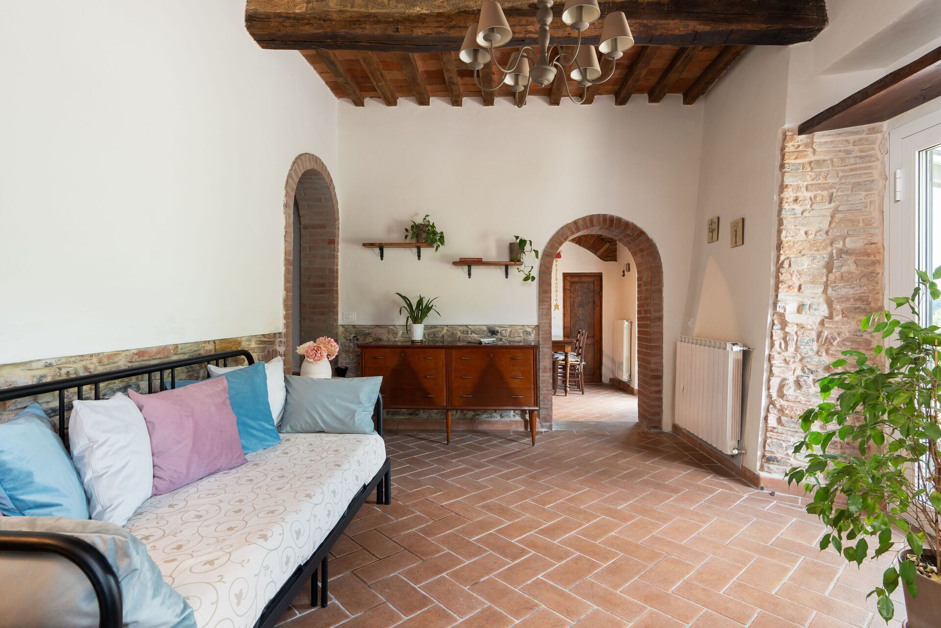 Una habitación acogedora con sofá, un aparador de madera y un comedor.