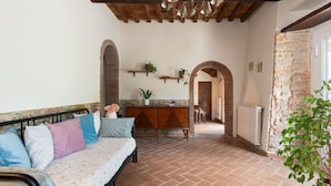 A cozy room with a sofa, a wooden cabinet, and a dining area.