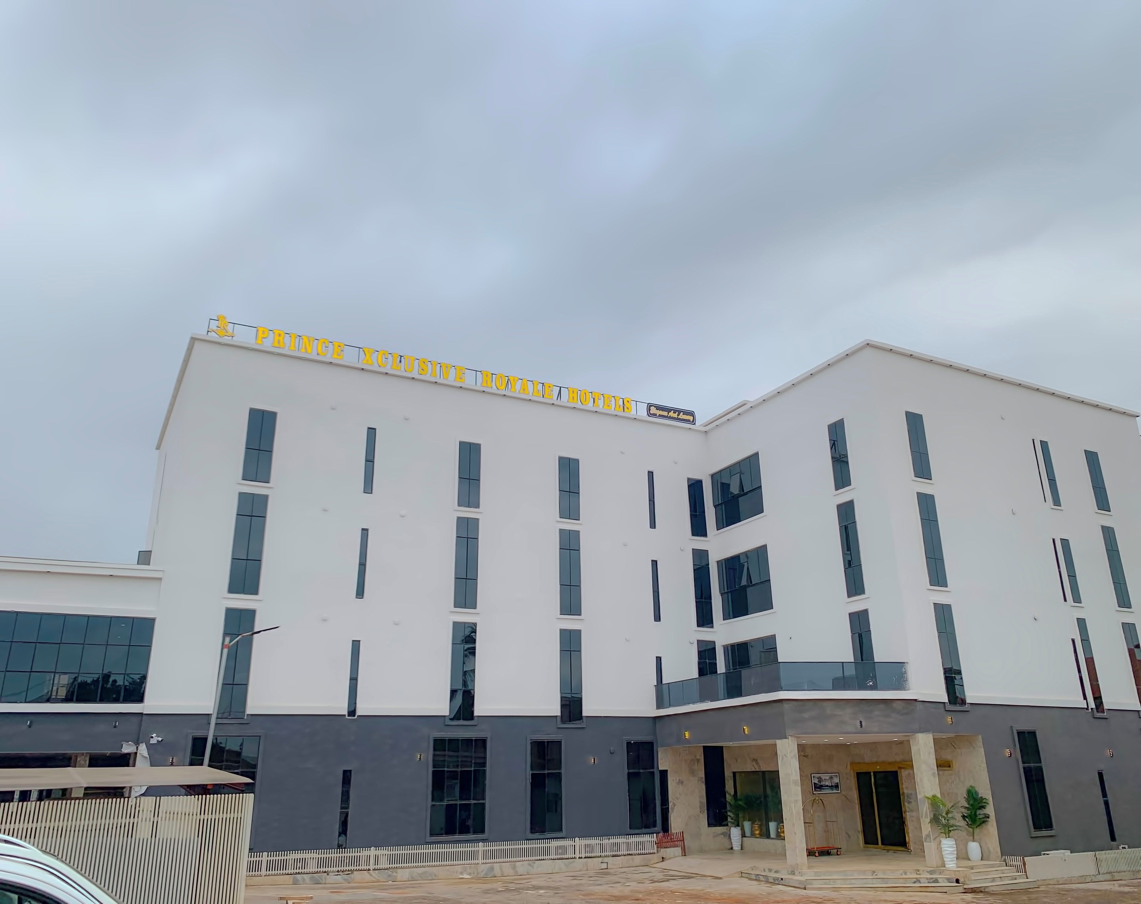 Ein mehrstöckiges Hotel mit heller Fassade, großen Fenstern und einer Beschriftung mit dem Schriftzug "PHRANCE XCLUSIVE ROYALE HOTELS".
