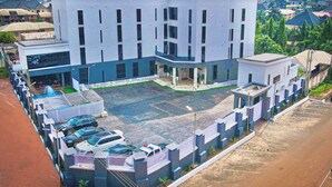 Un hôtel moderne doté d’une cour intérieure, de plusieurs étages et d’un parking pouvant accueillir plusieurs voitures.