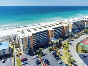 Ein Hotel mit Blick auf den Strand, Parkplätzen und einer Zufahrt.