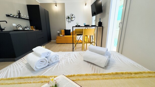 Una habitación de hotel con cama, escritorio, sofá y televisor.
