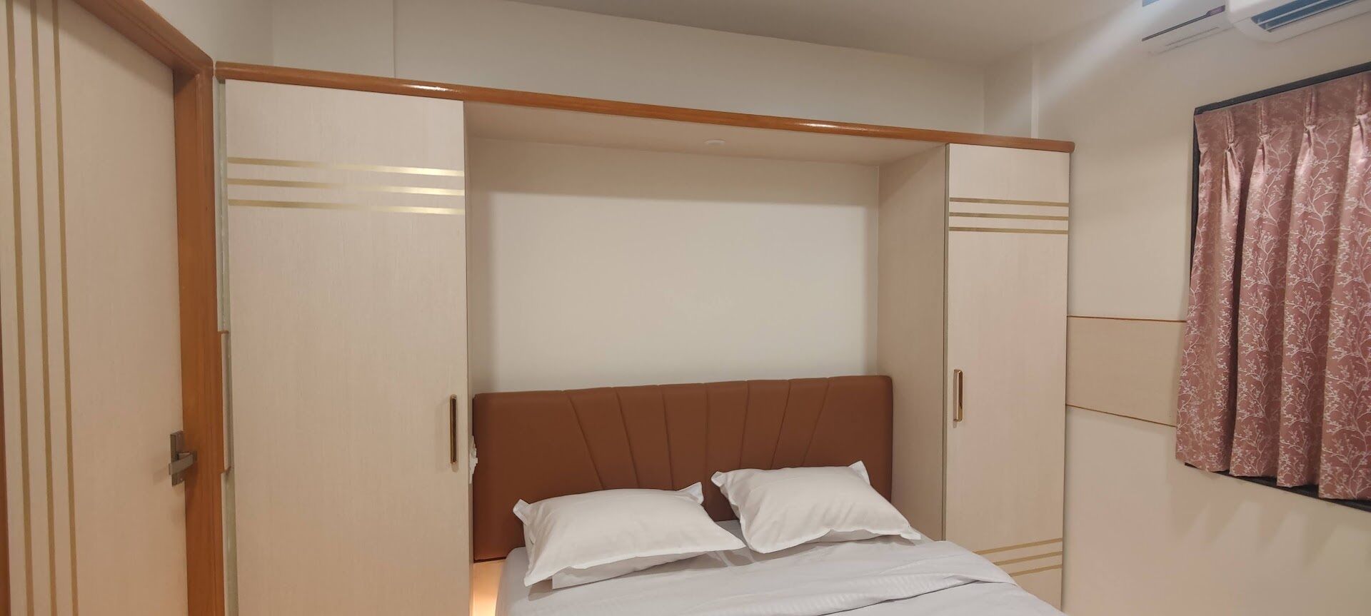 A bedroom with a bed, a wardrobe, and a curtain.