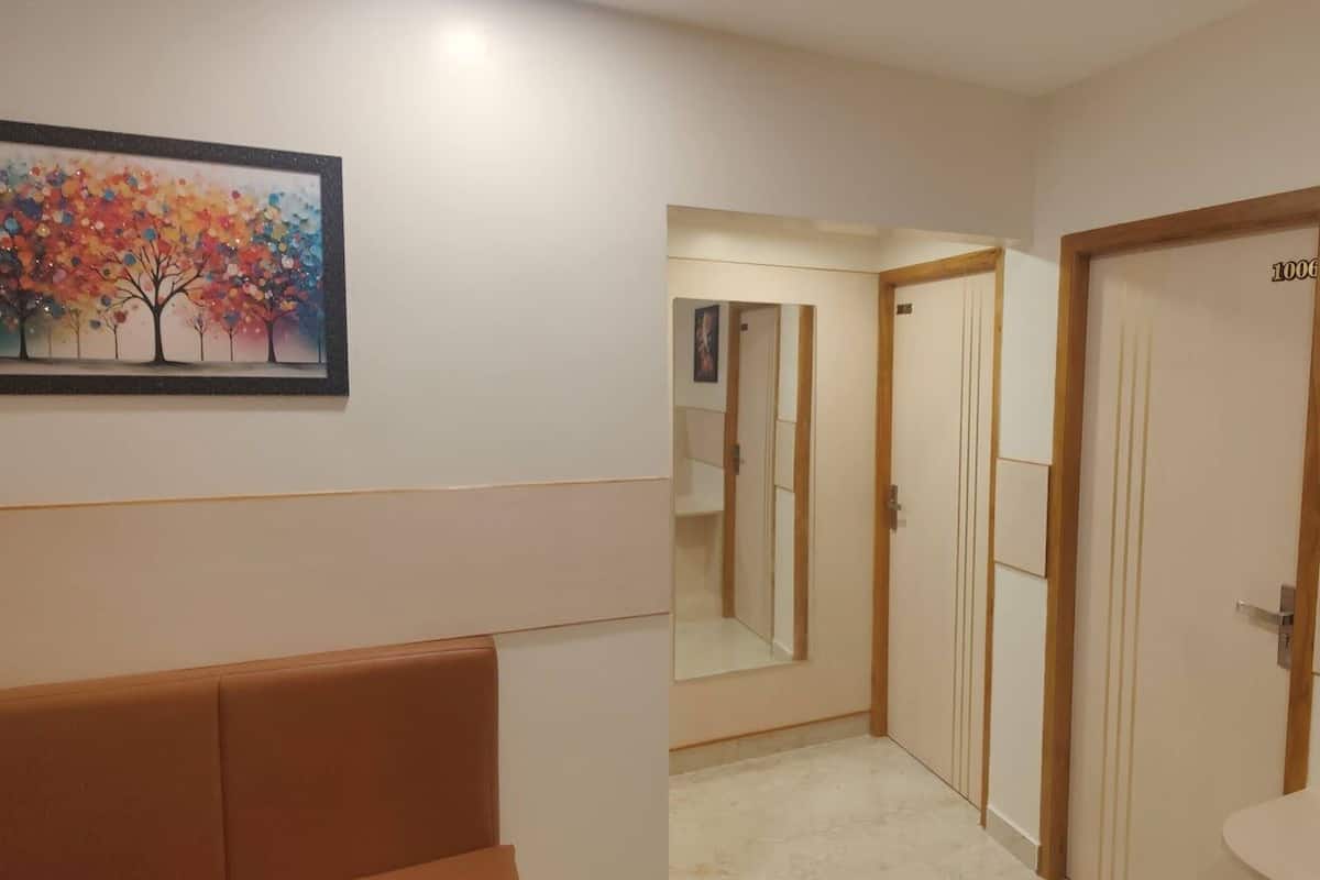 A hallway with a mirror, a door labeled "1006", and two framed artworks on the walls.