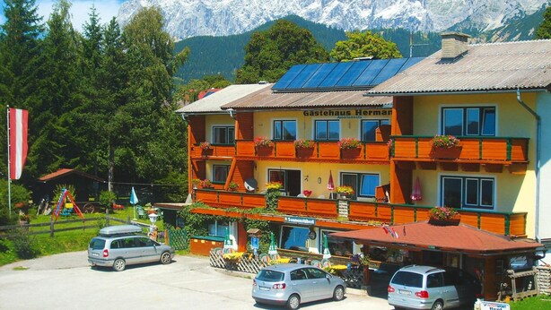 A hotel with multiple balconies, a mountain view, and a parking area. - Apartment in Vorberg Near Dachstein Glacier (Ramsau am Dachstein)