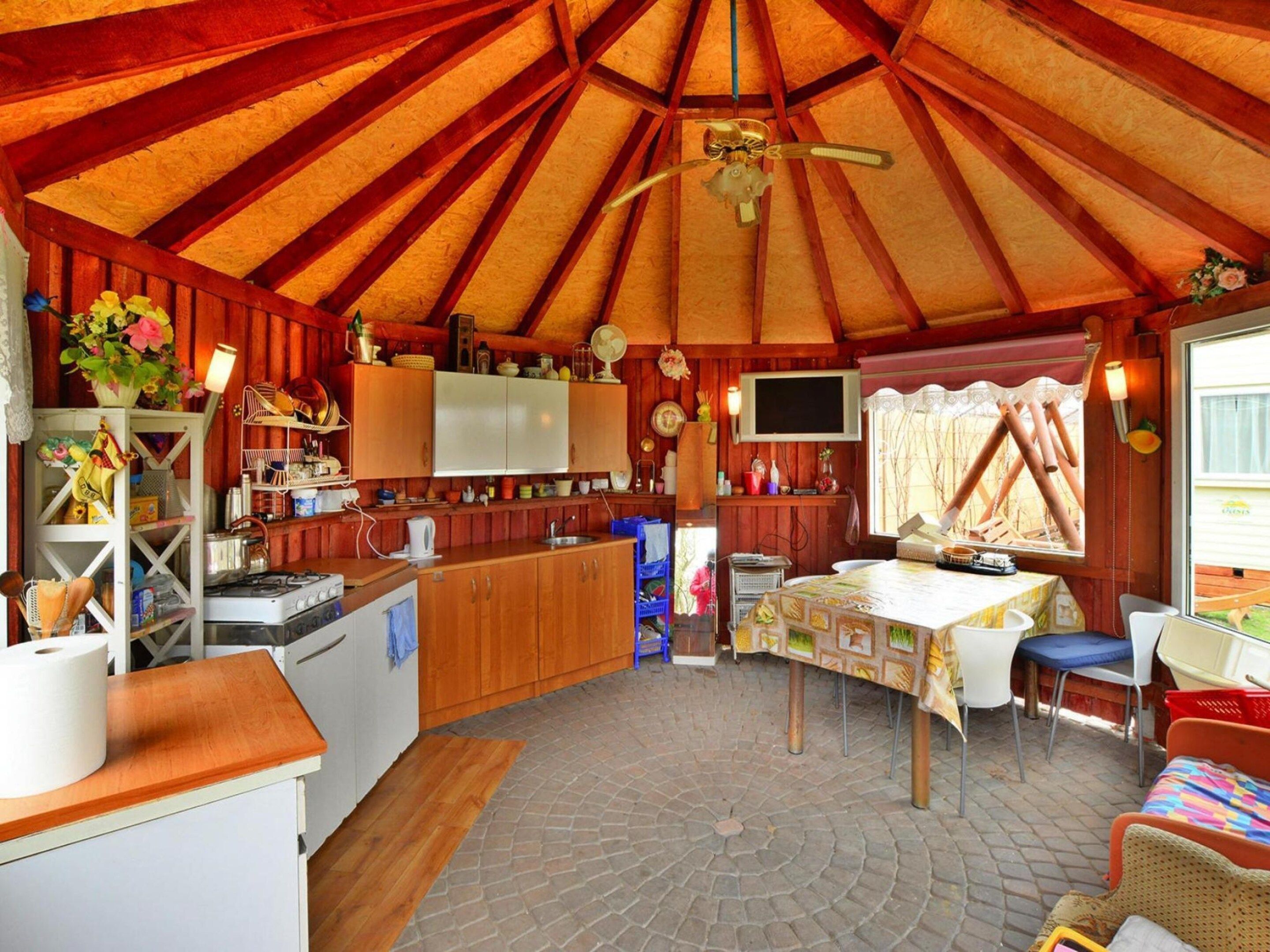 A cozy, rustic interior with a kitchen, dining area, and a large window.