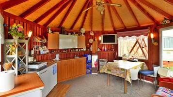 A cozy, rustic interior with a kitchen, dining area, and a large window.