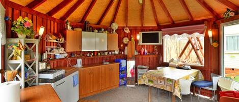 A cozy, rustic interior with a kitchen, dining area, and a large window.