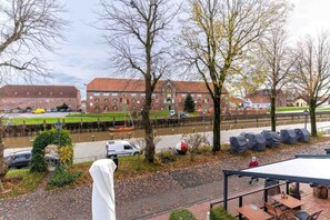 Enjoy riverside dining and relaxation at this serene riverside setting, featuring a traditional brick building and scenic views.