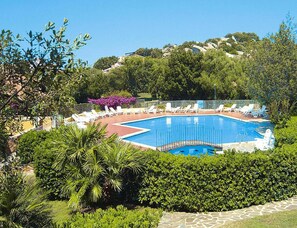 A swimming pool surrounded by lounge chairs and greenery. - Apartment in Sardinian Style With Pool (Olbia)