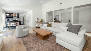 A modern living room with a white sofa, a wooden coffee table, and a patterned rug. - Austin Oasis – Zilker, Downtown, Pool, 3 Bedroom (Austin)