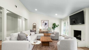 A modern living room with a sectional sofa, a coffee table, and a fireplace. - Austin Oasis – Zilker, Downtown, Pool, 3 Bedroom (Austin)