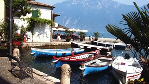 Ein Yachthafen mit vertäuten Booten, ein Gebäude mit Außenbereich und Berge im Hintergrund.