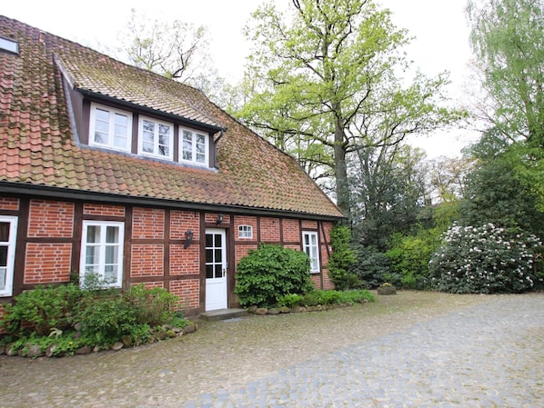 A traditional brick house with a tiled roof, a front door, and a small porch area. - Apartment in Dorfmark Near Luneburg Heath (Bad Fallingbostel)