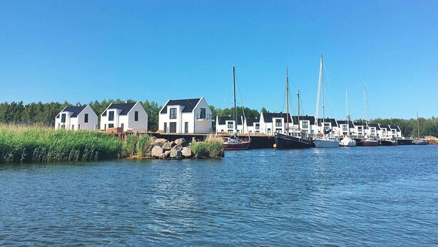 Un port de plaisance avec des maisons blanches et des voiliers.
