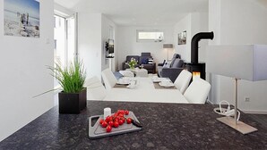 Un salon moderne comprenant un coin repas, une cheminée et un téléviseur.