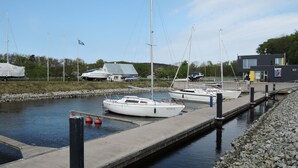 A marina with several sailboats docked at a concrete pier. - Holiday House Near Emerald Lake Wapnica (Międzyzdroje)