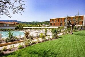 A hotel with a pool, outdoor seating, and a view of the hills. - Residence Olivo, Garda (Garda)