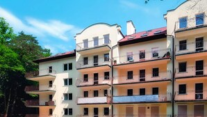 A multi-story residential building with balconies, a central staircase, and a flat roof. - Apartment <<morskie Oko B>> in Miedzyzdroje (Miedzyzdroje)