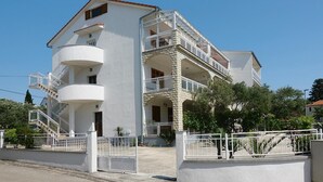 A multi-story building with balconies, a staircase, and a gated entrance. - Biograd Beachside Family Apartment (Biograd na Moru)