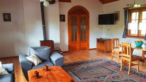 A cozy living room with a sofa, a wooden coffee table, a rug, and a fireplace. - Apartment in Masuria With Private Pond (Gizycko)
