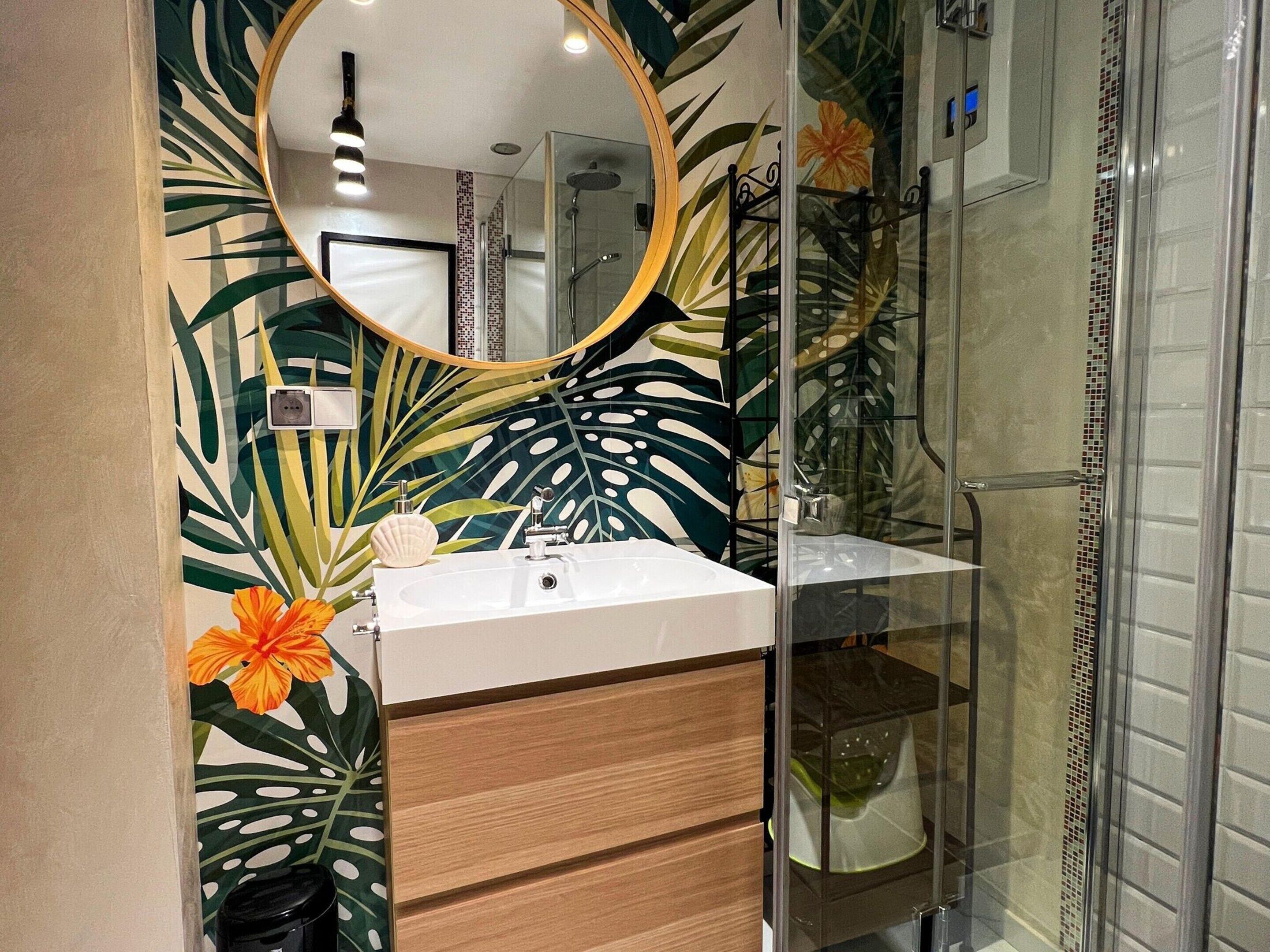 Une salle de bain avec une douche, un lavabo et un miroir.