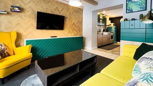 Una sala de estar moderna con una pared de diseño en espiga, un televisor de pantalla plana, un sofá amarillo y una pared de acento verde.