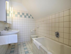 Un bany amb un lavabo, vàter i banyera.