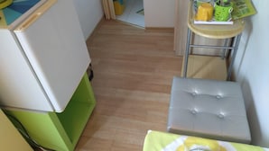 Una cucina funzionale con zona pranzo, che comprende un piccolo tavolo con una sedia, uno sgabello e un armadietto.
